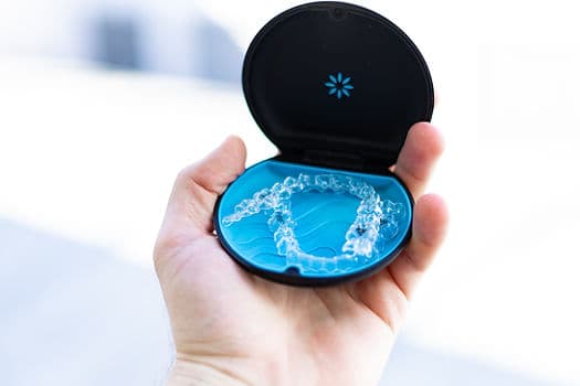 An Invisalign tray being fitted over the teeth