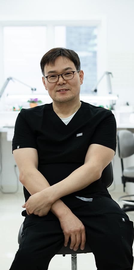 Sung, registered dental technician, seated at his laboratory bench
